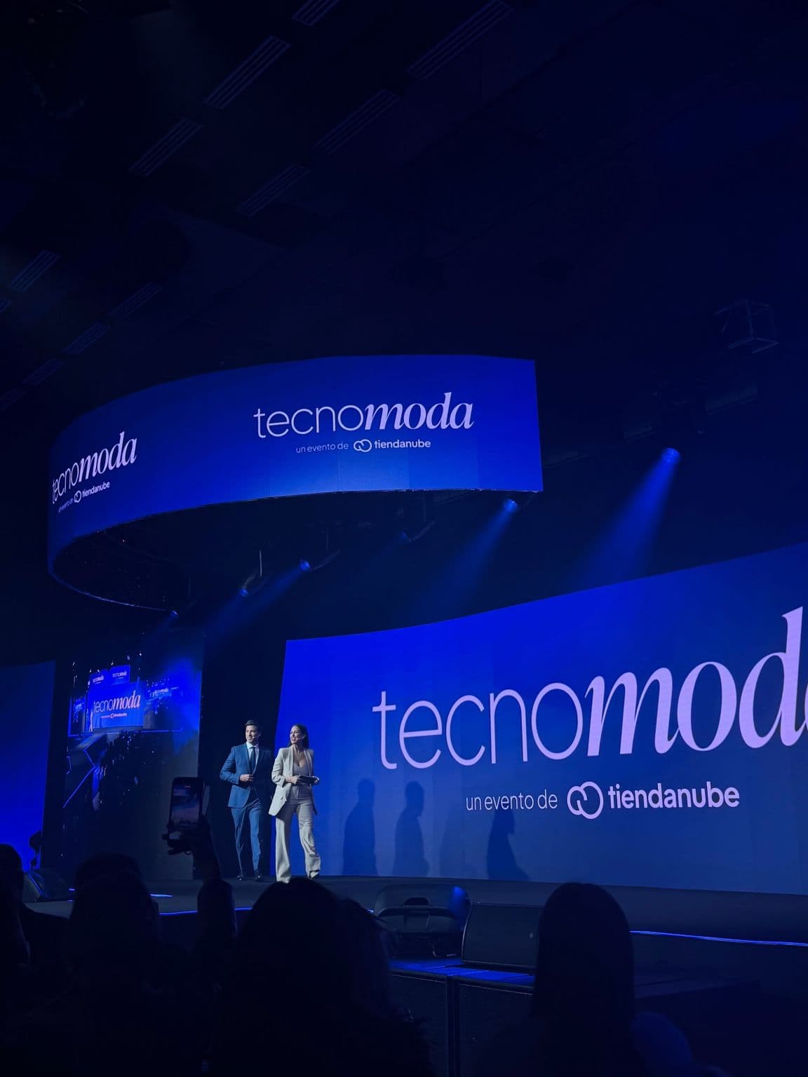 The Tecnomoda stage with the screen that reads “tecnomoda, un evento de tiendanube” and the hosts walking on.