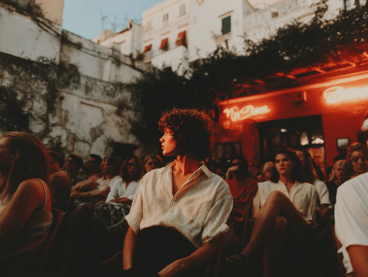 Gente conversando en la terraza de un bar iluminada con luces de neón